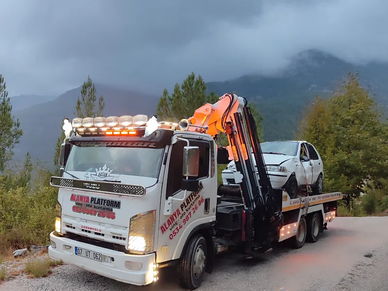 Orman yolunda duran beyaz platformlu kurtarıcı